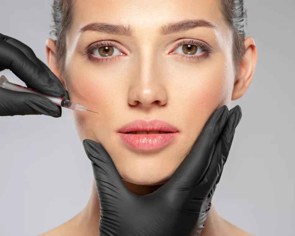 Young caucasian woman getting botox cosmetic injection near the eyes. Beautiful woman gets botox injection in her face. Adult girl gets cosmetic injection of botox in a clinic. Beauty treatments